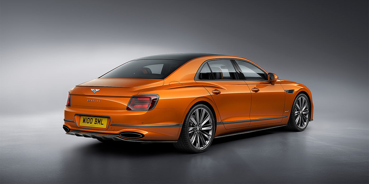 Bentley Riga Bentley Flying Spur Speed in Orange Flame colour rear view, featuring Bentley insignia and enhanced exhaust muffler.