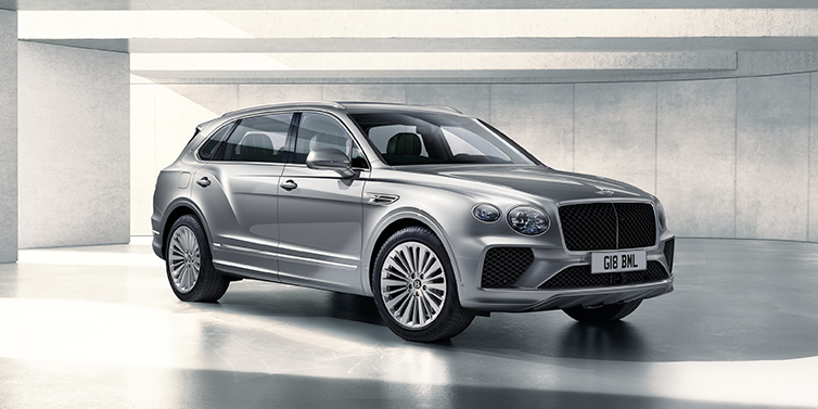 Bentley Riga Bentley Bentayga Extended Wheelbase SUV front three quarter in Moonbeam paint with a grey background